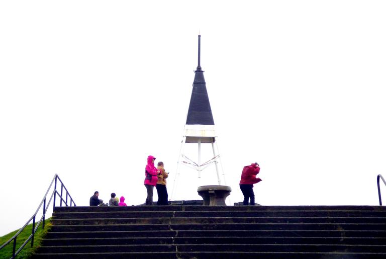 Kerri Walker;windblown;Tourists braving the elements up Mt Eden in a storm