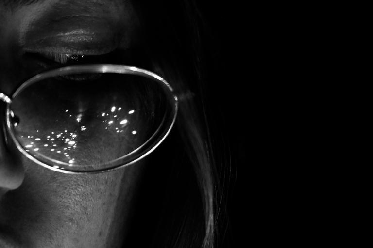 Auckland, Kohimarama. Late night fairy lights reflected in mothers glasses on self photographer model.