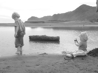Angela Gibson Baker; Discovery; Photo of a Brother and Sister at piha on overcast but warm day.