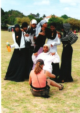 Julia Cotton; Girls on Film; This group of women posed for the photographer on the ground in front. Auckland International Cultural Festival