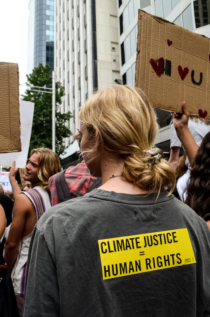 Angel Jacobson; Through Our Eyes; This was taken at the recent Intergenerational Climate Strike. It shows a girl who has stuck a bright sticker, reading,