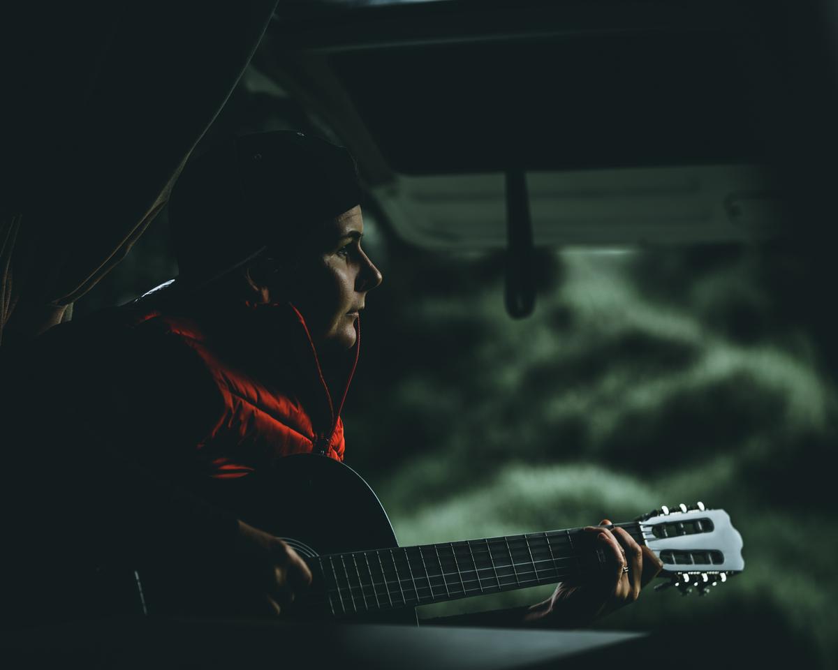 Paul Belli; Moody Chords; My wife is practicing playing the guitar in our campervan and the light catching her was as moody as her practice was at this time.
