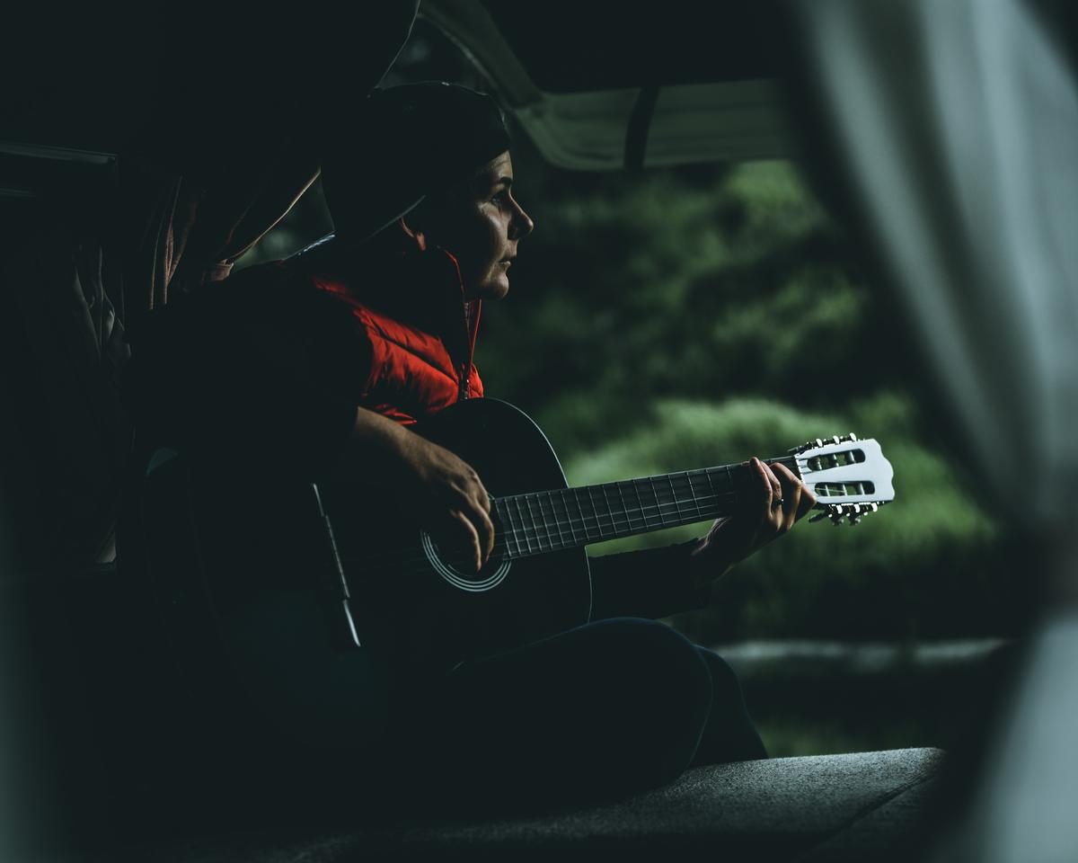 Paul Belli; Moody Chords 2; My wife is practicing playing the guitar in our campervan and the light catching her was as moody as her practice was at this time.
