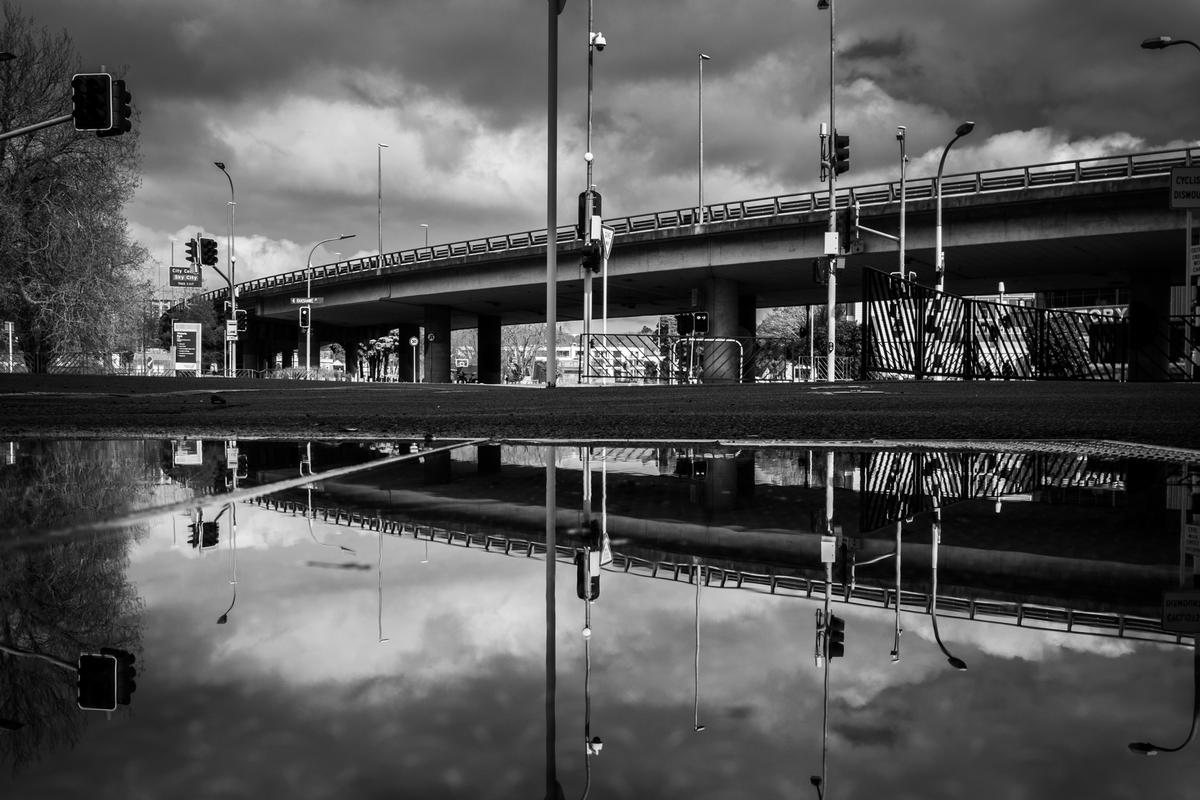 Andrew Malmo; Victoria Park Flyover in lockdown L4;This cool reflection in a puddle from Beaumont Street in Wynyard Quarter. No cars on the flyover.