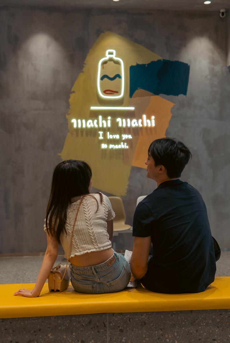 LEYAO LIU;Machi Love;Two people having a sweet time at a milk tea shop. They sit close together and look at each other with shy smiles as they wait for their drinks. The shop’s name and slogan, “Machi” and “I love you so machi”, add a touch of humor and charm to the scene. This photo captures the essence of love: subtle hints and hopeful hearts.