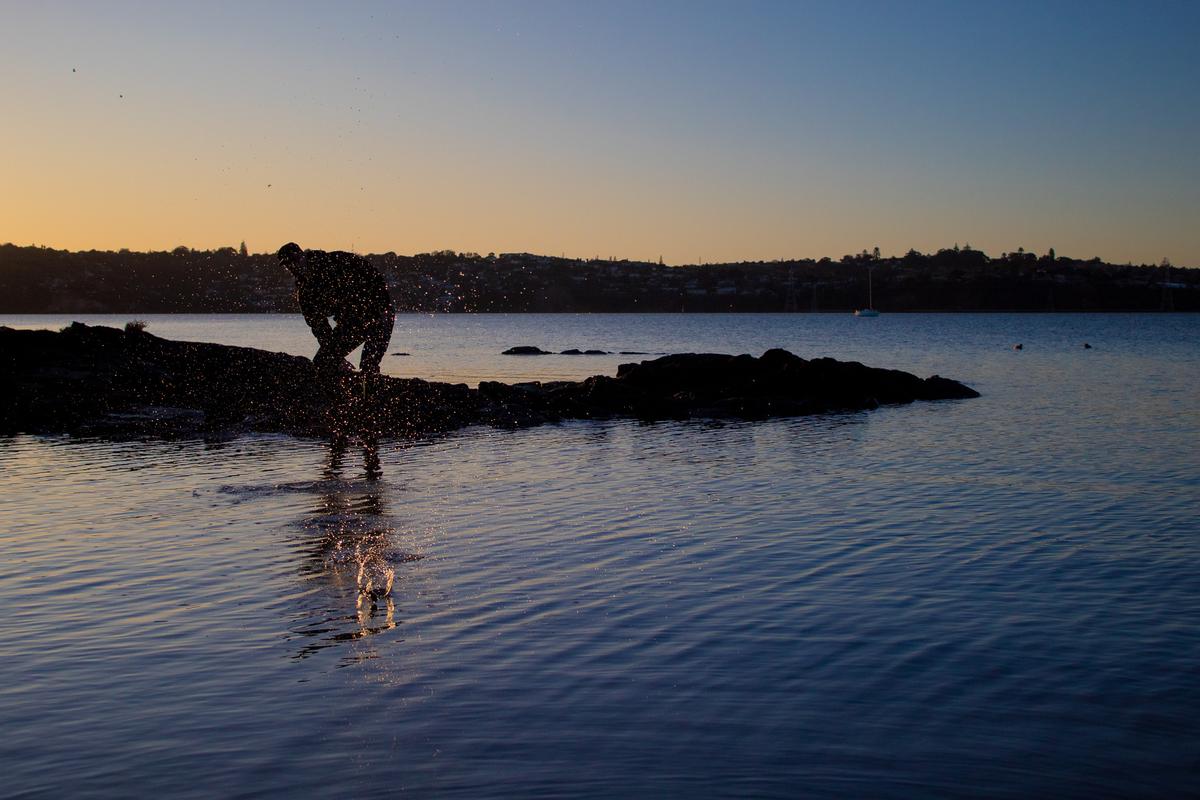 Reanna Hinds;Skimming;Capturing the beautiful combination of the sunset, the water and my dad skimming stones at the Mangere Bridge waterfront.