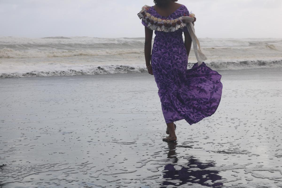 Preston Short;Pacific Island Serenity, Purple Elegance on the Shore;Enjoying the tranquil beauty of the beach, a figure gracefully moves along the sandy shore in a vibrant purple dress, embodying the essence of island serenity and elegance.