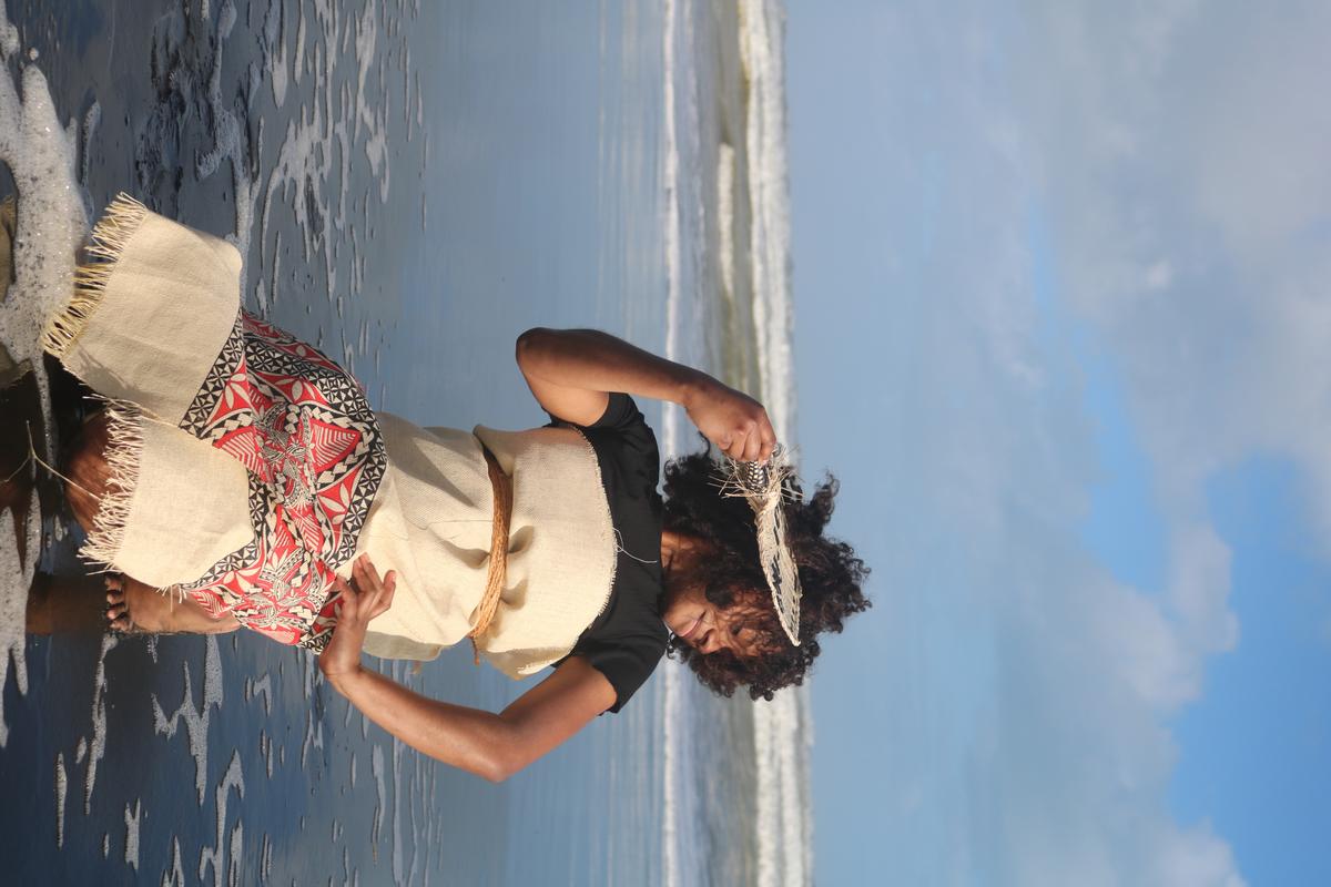 Preston Short;Fijian Meke;Capturing the beauty of a traditional Fijian dance a Fijian girl sits on the shore radiating with joyful energy.