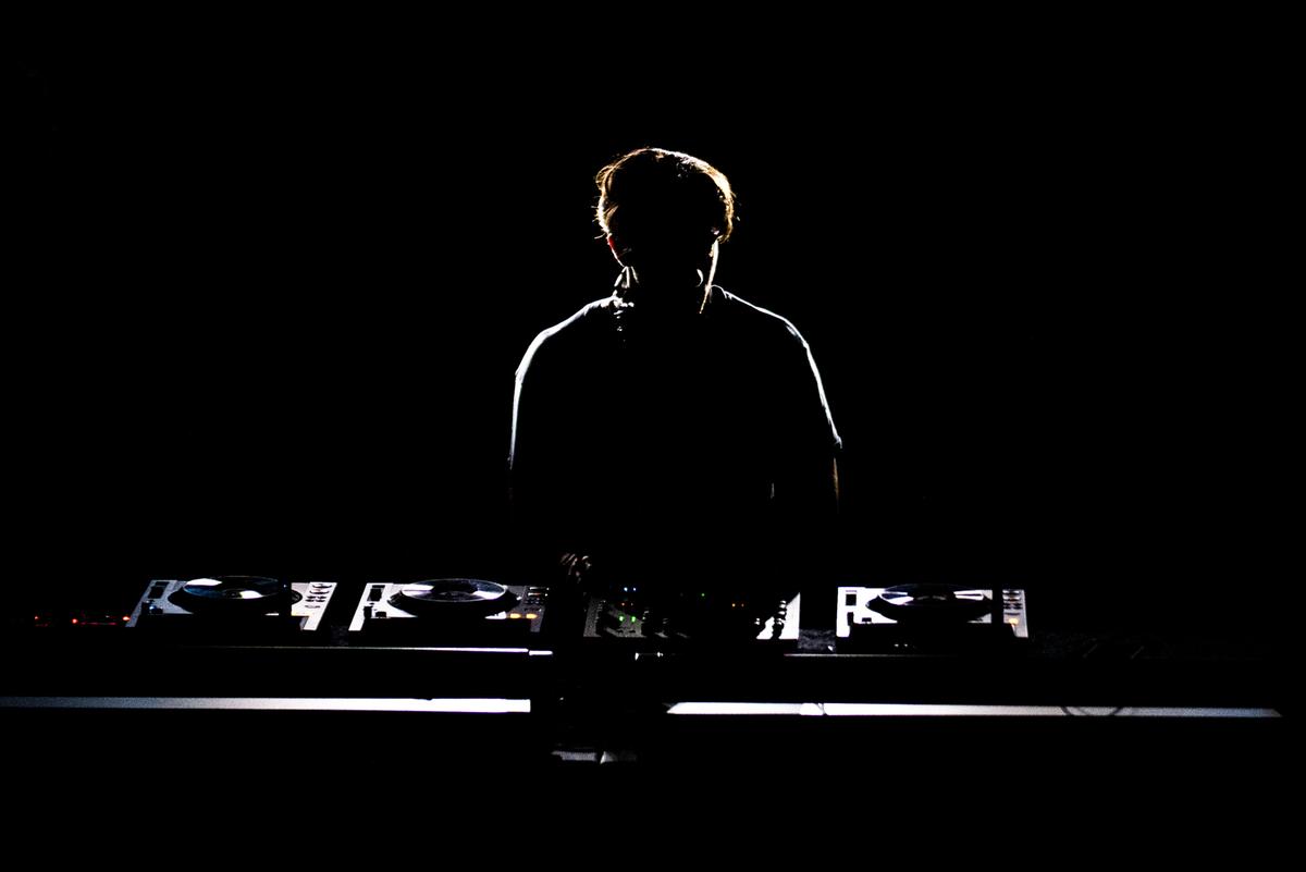 Mili Villamil;DJ Silhouette;The booth light and dark atmosphere creates a glowing edge around the DJ’s creating his silhouette.
