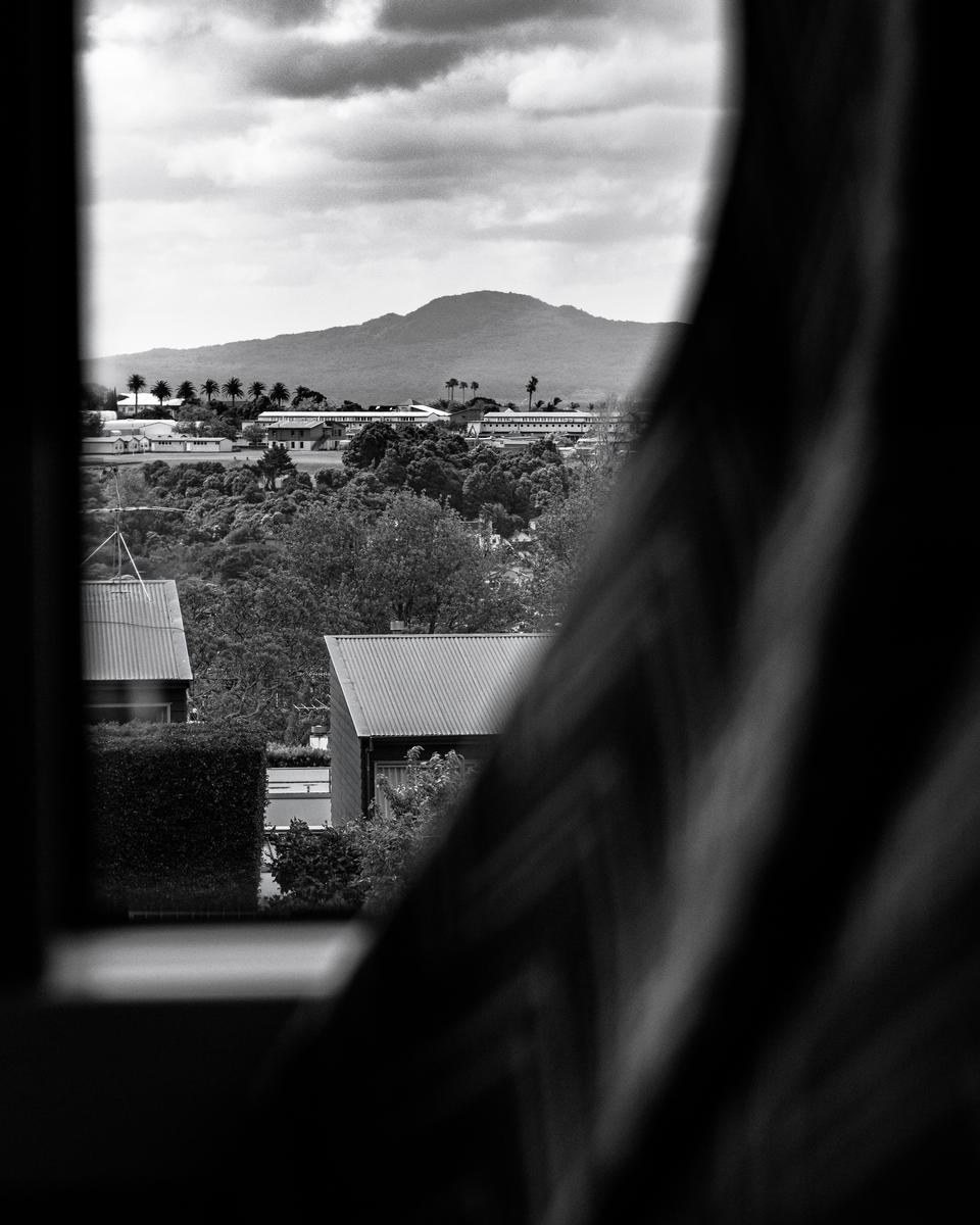 Daniel Clay;A Reflection of The Past;This photo was taken onboard the 75 bus from Glen Innes to Wynyard Quarter. I personally loved the contrast between the array of natural features and Rangitoto in looming in the background and the way humans have built upon this land which was once solely occupied by nature. It reflects issues which humans have created with urbanization and how as populations increase more and more natural land will be built upon and lose its natural values. It makes me reflect on what this land looked like before us humans occupied it.