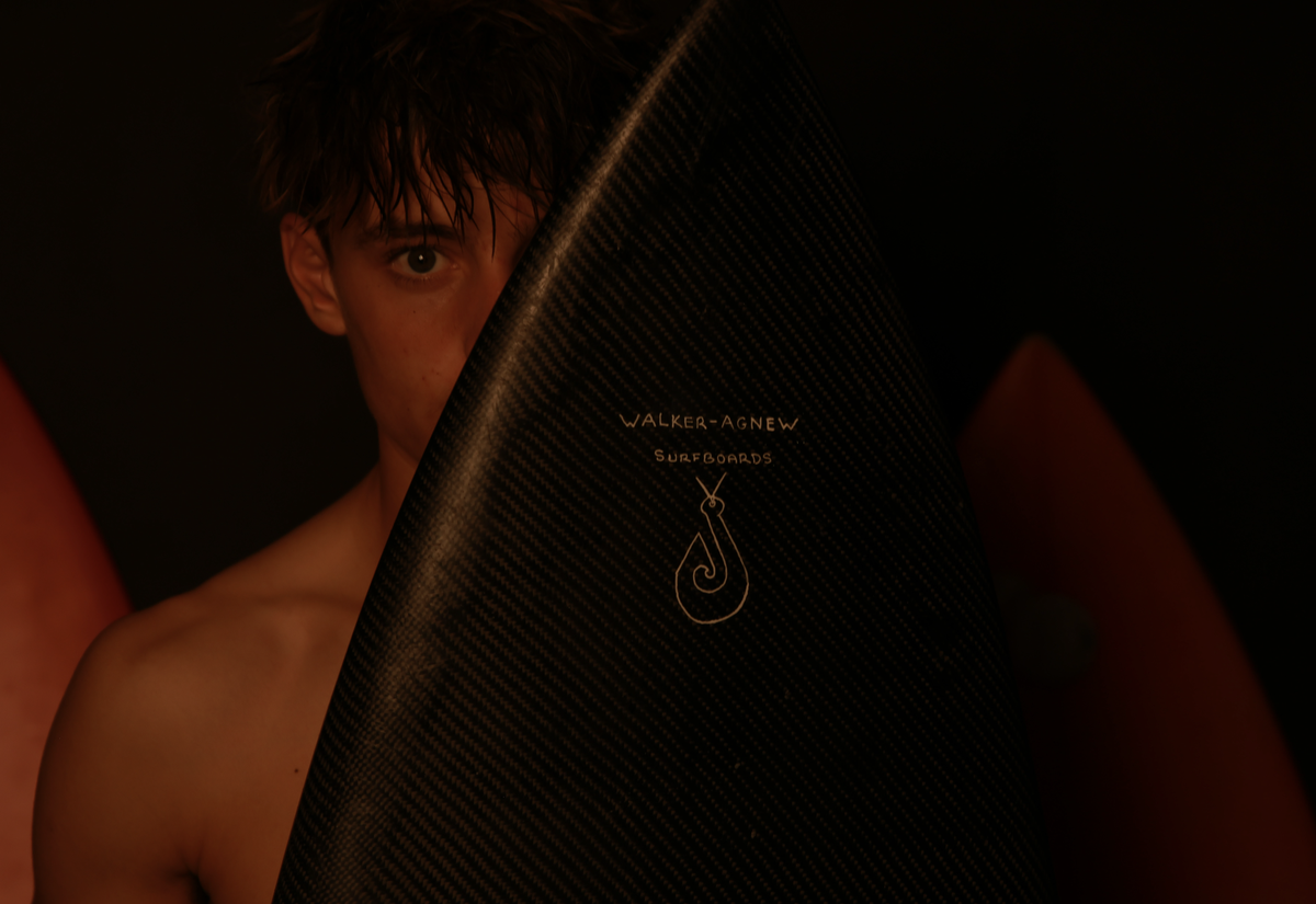 Indi Nicholas;Half seen;Behind the sleek curve of a surfboard, only one eye is visible—watchful, intense, and quiet. This image speaks to identity and vulnerability, showing just enough to feel known, but holding back more. It reflects the inner world of a surfer: focused, private, and deeply connected to something larger. It’s not just about the waves, but the person who faces them.