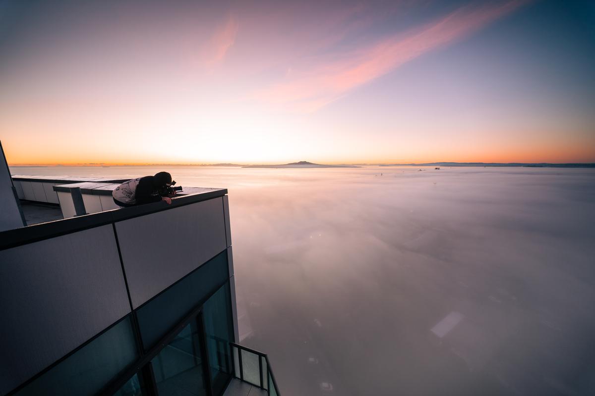 Kuan Chen;First light over Takapuna;Woken up by a call from my friend who told me there would be fog that morning, we both rushed out to Takapuna and were greeted by sunrise with a blanket of low fog over the entire city